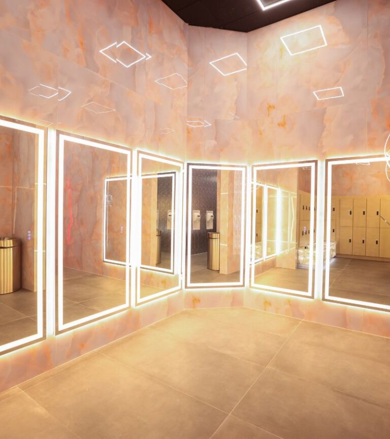 Luxury locker room with illuminated mirrors and premium finishes at Absolute Recomp Arlington.