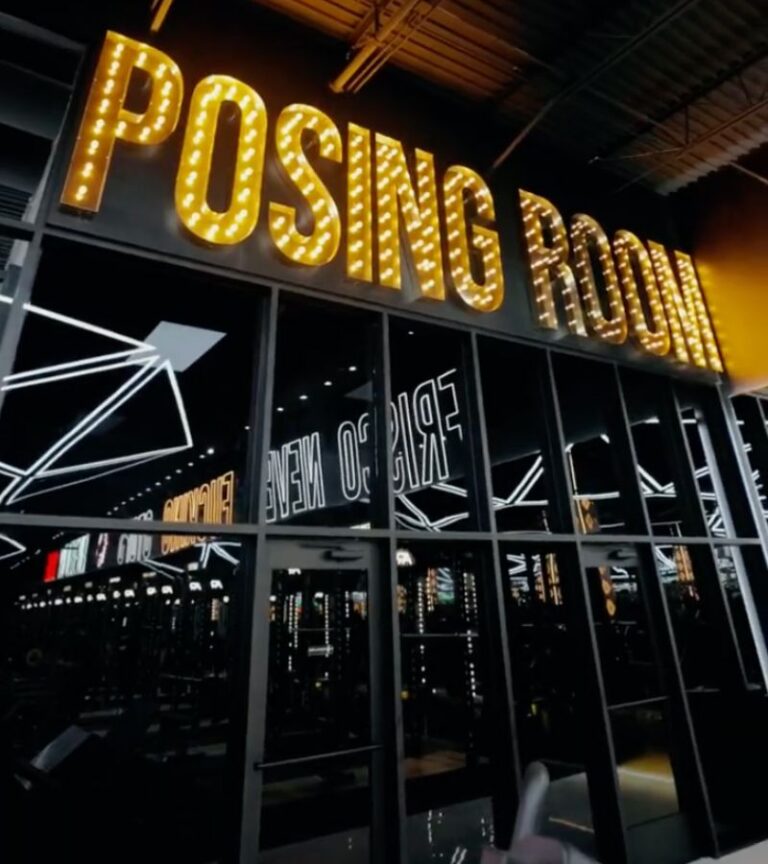 Illuminated posing room sign and mirrored entrance at Absolute Recomp Arlington