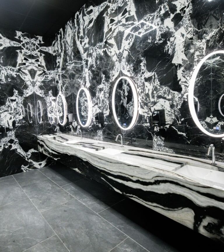 Absolute Recomp Frisco luxury locker room with modern marble design, backlit mirrors, and upscale amenities.