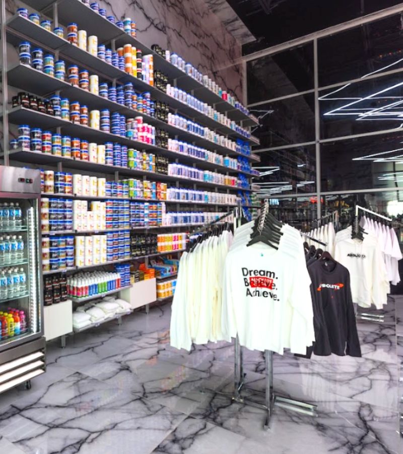 Retail area at Absolute Recomp Las Colinas featuring supplements, energy drinks, and branded apparel.