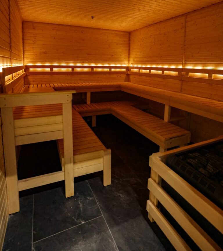Absolute Recomp gym sauna with wooden benches and warm ambient lighting for post workout recovery